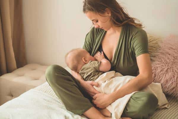 Mother and baby in breastfeeding session with focus on colic prevention